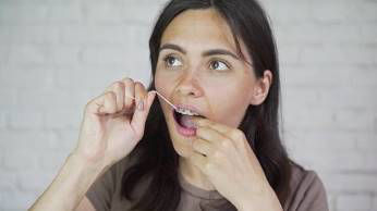 Flossing To Remove Plaque Building Bacteria Between Teeth 